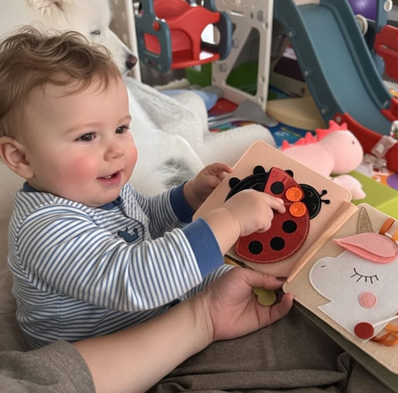 A baby playing with an open personalized felt quiet book on a play mat